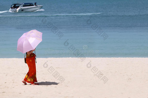 亚洲人旅行者女儿令人轻松的向指已提到的人海滩