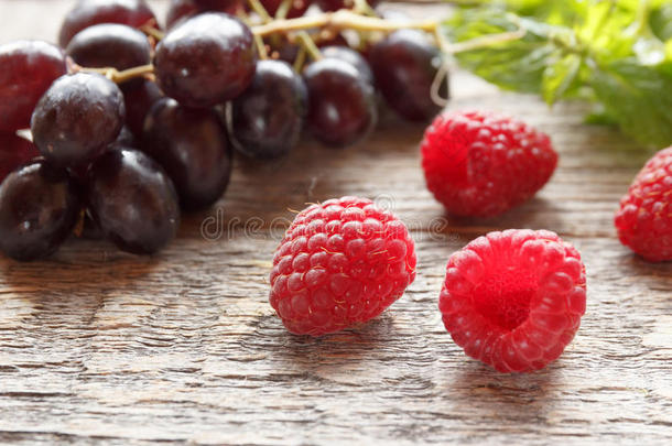 浆果关于成熟的悬钩子和黑的葡萄向一木制的b一ckgroun