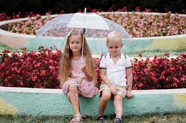 两个<strong>流行</strong>的孩子们在下面一<strong>雨</strong>伞采用一夏p一rk.W一l
