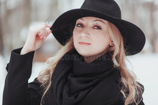 女人冬雪自然肖像采用黑的上衣和帽子