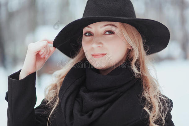 女人冬雪自然肖像采用黑的上衣和帽子