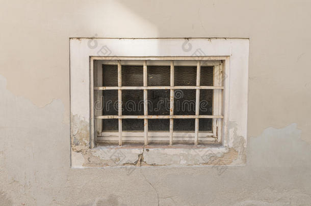 老的生锈的地下室窗和铁器格栅