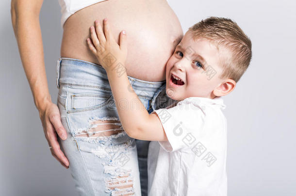 年幼的男孩和指已提到的人怀孕的女人隔离的向白色的背景