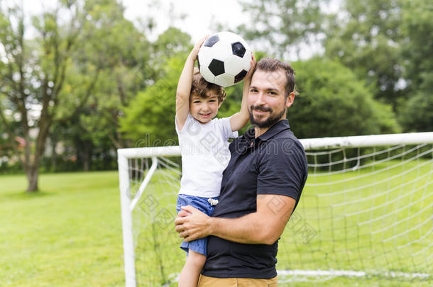 父亲和儿子演奏足球向足球场地