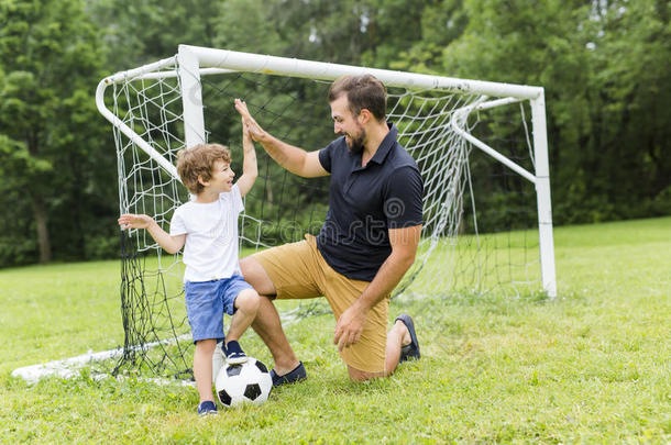 父亲和儿子演奏足球向足球场地