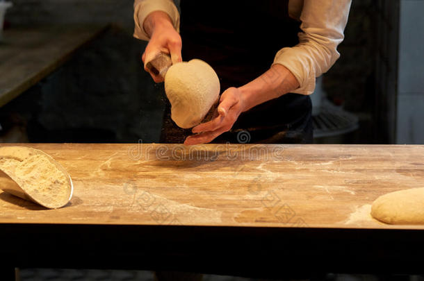 面包师分份生面团和长凳切削者在面包房