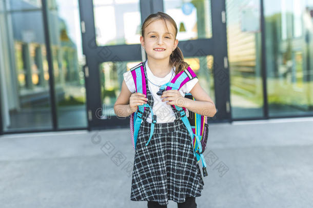女孩起立在外面学校和袋