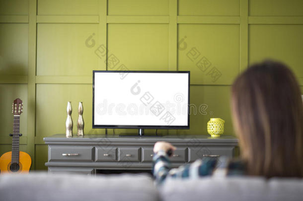 美丽的女人观察televisi向电视机一次向长沙发椅在家