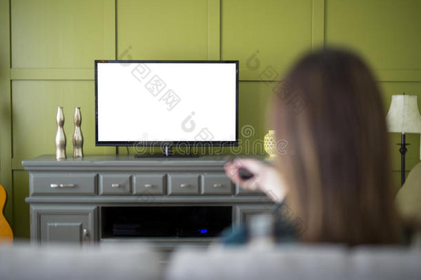美丽的女人观察televisi向电视机一次向长沙发椅在家