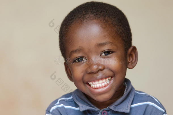英俊的小的非洲的男孩肖像微笑的和露出牙齿的微笑