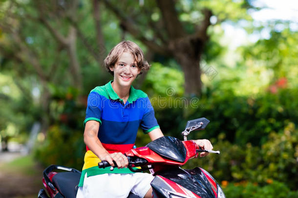 十几岁的青少年骑马小型摩托车.男孩向摩托车.