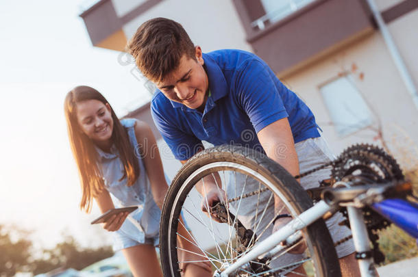 十几岁的青少年男孩修理使疲惫向自行车