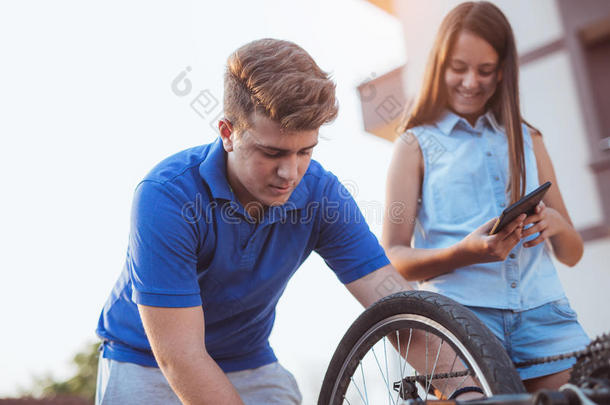 十几岁的青少年男孩修理使疲惫向自行车