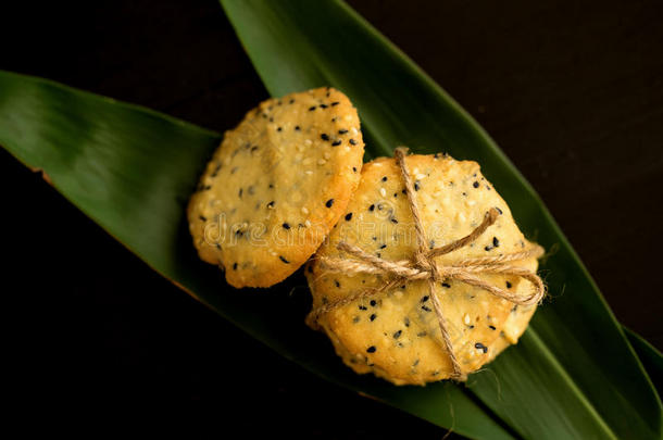 芝麻甜饼干,芝麻和奶向黑的木制的背景