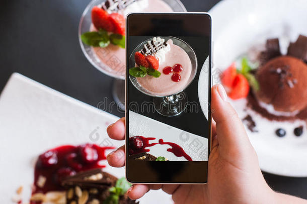 食物照片关于多乳脂的或似乳脂的甜食在旁边智能手机