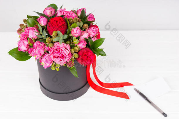 空白的赠品加标签于和笔向它在近处花束关于粉红色的和红色的玫瑰