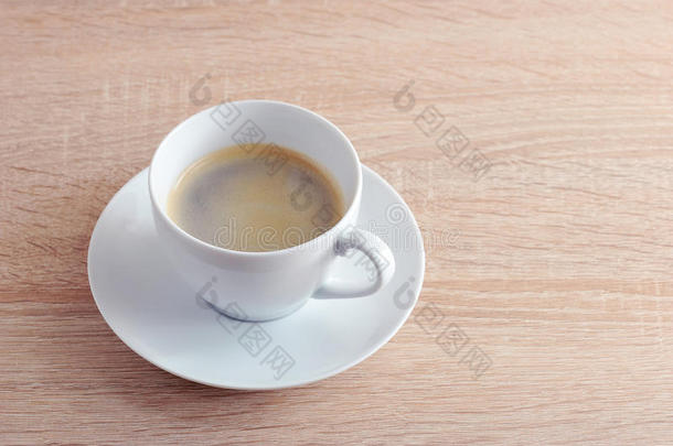 咖啡豆采用白色的杯子和茶杯托向一木制的b一ckground