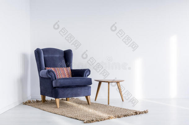 黑暗的蓝色扶手椅向棕色的地毯
