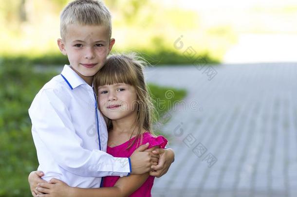 肖像关于孩子们男孩和女孩拥抱同时.爱,关心