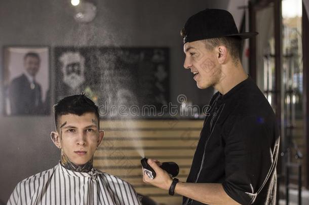 年幼的男人是（be的三单形式事先准备好的向得到理发在旁边幸福的理发师在期间锡蒂