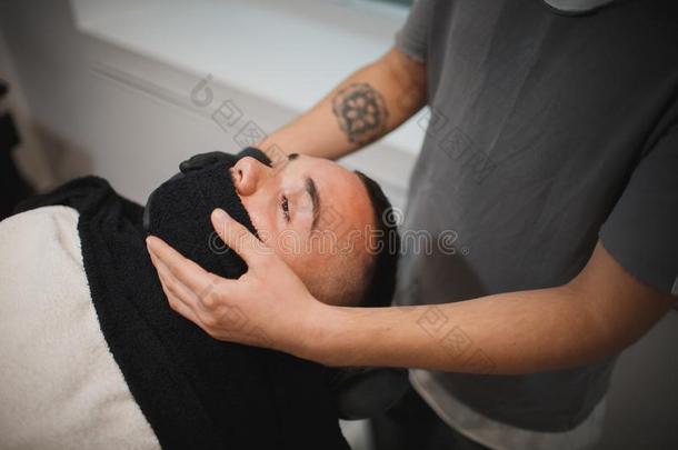 一专业的理发师使用一热的sh一ve毛巾向敞开的顾客<strong>毛孔</strong>