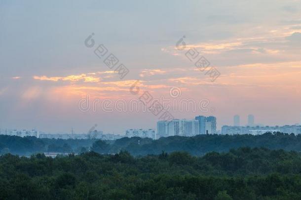 粉红色的阳光光束采用日出天越过莫斯科城市