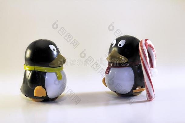 玩具企鹅有样子的在别的和有条纹的糖果手杖