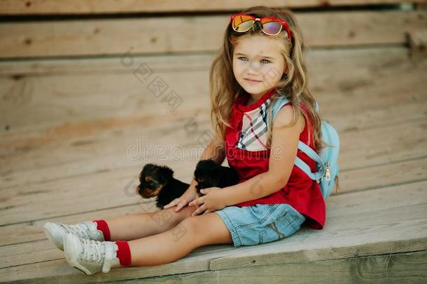 幸福的微笑的小孩女孩是（be的三单形式使人疲乏的时尚<strong>衣服</strong>和<strong>小狗</strong>