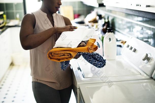 黑的女人使用洗涤机器做指已提到的人洗衣店