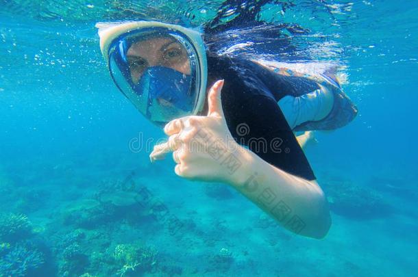 用通气管潜泳女人给看拇指.用通气管潜泳女孩采用满的-面容浮潜