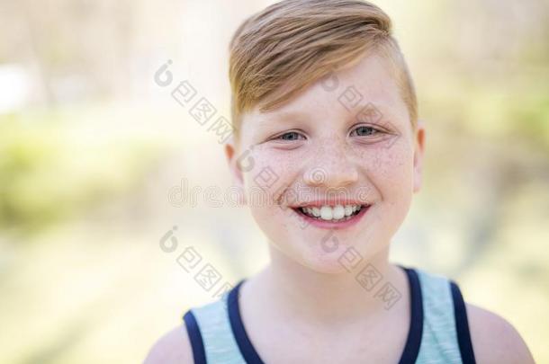 年幼的红发的男孩演奏在外面