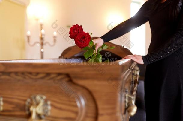 女人和红色的玫瑰和棺材在葬礼