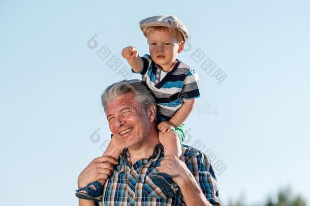 祖父支撑孙子蹒跚行走的人男孩向他的肩