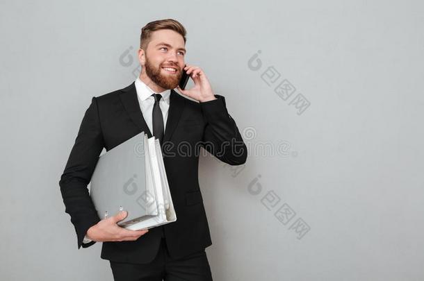微笑的有胡须的男人采用一套外衣talk采用g向指已提到的人smartph向e