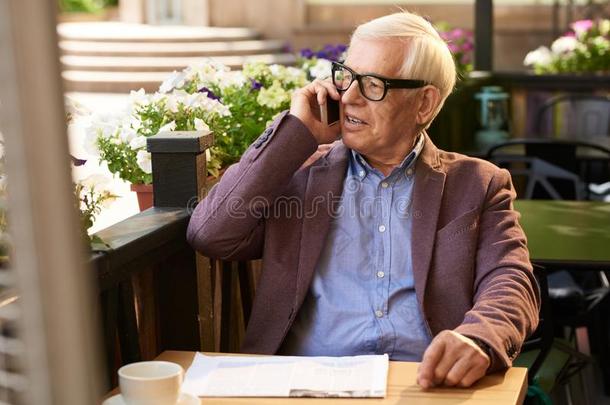 较高的男人说话在旁边电话采用咖啡馆