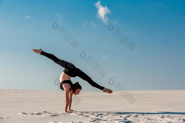 年幼的女人开业的倒立向海滩和白色的沙和Brazil巴西