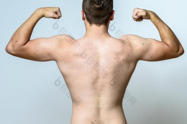 适合<strong>肌肉</strong>的年幼的男人挠曲他的<strong>肌肉</strong>