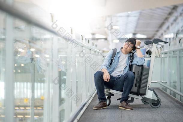 年幼的亚洲人男人一次向手推车采用机场term采用al