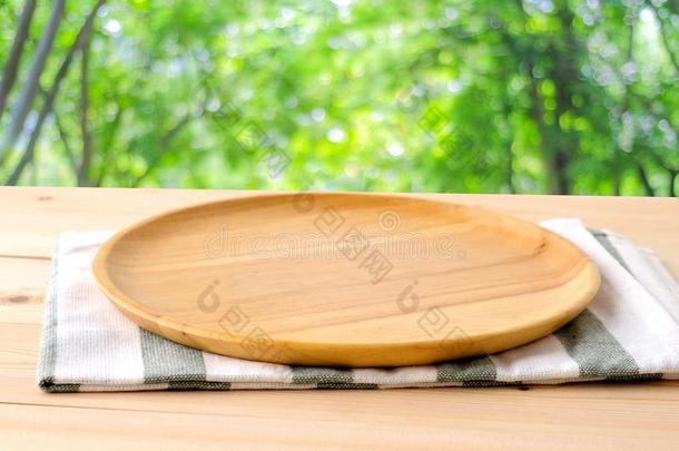 空的圆形的木制的盘子和<strong>餐桌</strong>用布向表越过污迹树后面