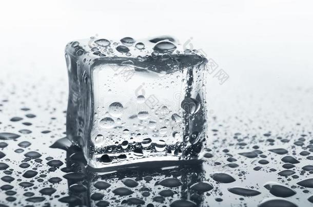 透明的冰立方形向玻璃和水落下