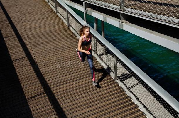 女运动家跑步和短距离疾跑穿过一桥