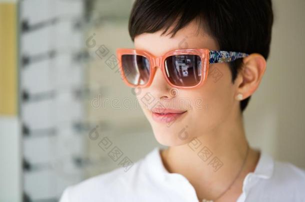 年幼的美丽的女人在<strong>眼镜</strong>商和<strong>眼镜</strong>购买sun<strong>眼镜</strong>