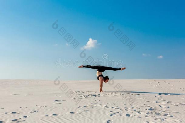 年幼的女人开业的倒立向海滩和白色的沙和Brazil巴西