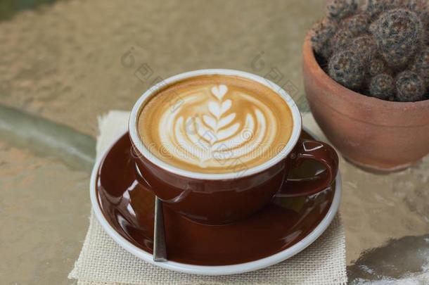 热的咖啡豆拿铁咖啡和美丽的起泡沫艺术向玻璃表.户外的