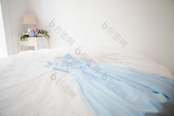 蓝色婚礼衣服谎言越过白色的床采用一旅馆房间