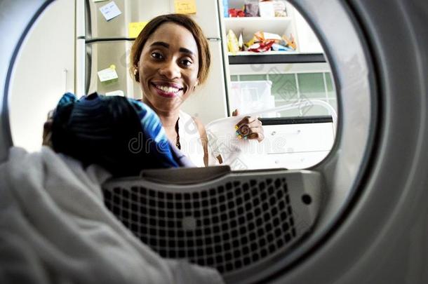 黑的女人使用洗涤<strong>机器</strong>做指已提到的人洗衣店
